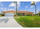 Inviting home featuring a manicured lawn and a spacious driveway leading to a two-car garage at 1836 Ironwood Ct, Venice, FL 34293