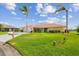Exterior view of home with palm trees, green lawn and tile roof at 1836 Ironwood Ct, Venice, FL 34293