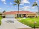 Charming home featuring a well-manicured lawn and a spacious driveway leading to a two-car garage at 1836 Ironwood Ct, Venice, FL 34293