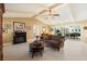 Comfortable living room with fireplace and pool view through large sliding glass doors at 1836 Ironwood Ct, Venice, FL 34293