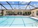 Screened-in pool with sun-lounger, waterfront, and adjacent covered lanai at 1836 Ironwood Ct, Venice, FL 34293