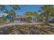 Charming single-story home featuring a blue exterior, well-maintained lawn, and mature palm trees at 1931 Bahia Vista St, Sarasota, FL 34239