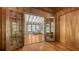 Wood-paneled room with glass French doors revealing living room with exposed beam ceiling and hardwood floors at 1931 Bahia Vista St, Sarasota, FL 34239
