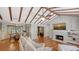 Bright living room features exposed beam ceiling, fireplace, hardwood flooring, and comfortable seating at 1931 Bahia Vista St, Sarasota, FL 34239