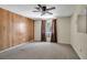 Bedroom featuring carpet, wood paneling, a ceiling fan, and a window with curtains at 2040 Edmondson Rd, Nokomis, FL 34275