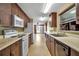 Well-lit kitchen area featuring wood cabinetry, white appliances, and a spacious layout at 2040 Edmondson Rd, Nokomis, FL 34275