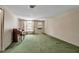 Bright living room featuring green carpet, natural light, and a vintage piano at 2040 Edmondson Rd, Nokomis, FL 34275