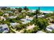 Bright and airy aerial view showing lush landscaping, turquoise waters, and beautiful real estate at 205 Elm Ave, Anna Maria, FL 34216