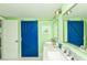 This bathroom offers double sinks, a bright blue barn door and coastal decorations, adding a pop of color at 205 Elm Ave, Anna Maria, FL 34216