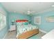 Comfortable bedroom with turquoise walls, coastal-themed bedding, ceiling fan, and plenty of natural light at 205 Elm Ave, Anna Maria, FL 34216