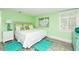 This bedroom offers a serene retreat with its white bedding, colorful art and cool-tone decor at 205 Elm Ave, Anna Maria, FL 34216