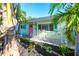 Exterior shot showcasing a charming home with a porch and lush, tropical landscaping at 205 Elm Ave, Anna Maria, FL 34216