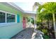 Charming home featuring a welcoming porch and beautiful landscaping at 205 Elm Ave, Anna Maria, FL 34216