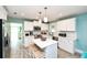 This kitchen features white cabinetry, stainless appliances, an island and modern fixtures, making it perfect for cooking at 205 Elm Ave, Anna Maria, FL 34216