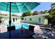 Outdoor dining area next to the sparkling pool with seating, pool views, and comfortable lounge chairs at 205 Elm Ave, Anna Maria, FL 34216
