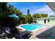 Inviting backyard pool area with spa, tropical landscaping, and lounging chairs for relaxation and enjoyment at 205 Elm Ave, Anna Maria, FL 34216
