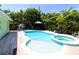 Relaxing backyard pool featuring an in-ground spa, comfortable lounging chairs and a barbecue grill at 205 Elm Ave, Anna Maria, FL 34216