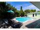 Enjoy relaxing by the pool in this tropical backyard, complete with lounge chairs and lush greenery at 205 Elm Ave, Anna Maria, FL 34216