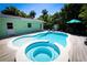 Backyard oasis featuring a pool, spa, and lush landscaping, perfect for relaxation at 205 Elm Ave, Anna Maria, FL 34216