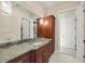 Bathroom with granite counters, wood cabinets, decorative light fixtures and tile floors at 20706 79Th E Ave, Bradenton, FL 34202