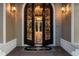 Close-up of an ornate front door with custom ironwork, exterior sconces and marble tiled foyer at 20706 79Th E Ave, Bradenton, FL 34202