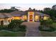 Elegant home exterior boasts an arched entry, lush landscaping, and a terracotta tiled roof at 20706 79Th E Ave, Bradenton, FL 34202