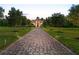 Stunning estate home with a long brick driveway lined with manicured trees and illuminated landscape lighting at 20706 79Th E Ave, Bradenton, FL 34202