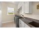 Bright laundry room features modern washer/dryer, white cabinets and granite countertop at 20706 79Th E Ave, Bradenton, FL 34202
