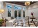 Living room with marble floors, coffered ceilings, a chandelier, and French doors to the backyard and pool at 20706 79Th E Ave, Bradenton, FL 34202