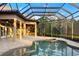 Beautiful screened-in pool area featuring a travertine tile deck and outdoor kitchen at 20706 79Th E Ave, Bradenton, FL 34202