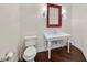 Quaint powder room features white fixtures and unique red framed mirror at 20706 79Th E Ave, Bradenton, FL 34202