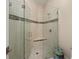 Modern shower with frameless glass enclosure, built-in seat, and decorative tile accent at 20706 79Th E Ave, Bradenton, FL 34202