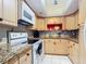 Charming kitchen with white appliances, granite countertops, and light wood cabinetry at 21300 Brinson Ave # 214, Port Charlotte, FL 33952