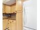 A kitchen featuring light wood cabinetry, granite countertops, and a white refrigerator at 21300 Brinson Ave # 214, Port Charlotte, FL 33952