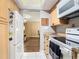 A kitchen with white appliances, light wood cabinets and access to another room at 21300 Brinson Ave # 214, Port Charlotte, FL 33952