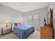 Cozy bedroom with a large window, closet and plush carpet with comfortable bedding and furnishings at 224 Caserta Ct, Nokomis, FL 34275