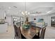 Spacious dining area open to kitchen and living room, featuring modern chandelier and ample natural light at 224 Caserta Ct, Nokomis, FL 34275