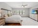 The main bedroom is spacious with a large window, ceiling fan, and decorative rug at 224 Caserta Ct, Nokomis, FL 34275