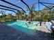 Screened-in pool and spa with a covered patio and beautiful view of surrounding foliage at 224 Caserta Ct, Nokomis, FL 34275