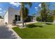 Spacious backyard with artificial turf, patio area, and tropical landscaping offers a serene outdoor space at 2365 Novus St, Sarasota, FL 34237