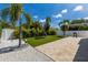 Large backyard featuring pavers, artificial turf, lush tropical landscaping, and a grill at 2365 Novus St, Sarasota, FL 34237