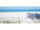 Peaceful beachfront view with tranquil turquoise waters, white sand, and the shadow of a palm tree at 2365 Novus St, Sarasota, FL 34237