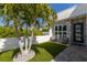 Welcoming front courtyard with green artificial lawn, light-colored walls, and outdoor seating near entrance at 2365 Novus St, Sarasota, FL 34237