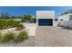 Modern home with a two-car garage, neutral colored exterior, with clean landscape features and pavers at 2365 Novus St, Sarasota, FL 34237