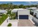 Well-maintained home with a blue garage door, brick driveway, green lawn, and front courtyard at 2365 Novus St, Sarasota, FL 34237