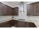 Modern kitchen featuring granite countertops, wood cabinets, stainless-steel vent, and a light backsplash at 2365 Novus St, Sarasota, FL 34237