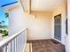A balcony with neutral painted walls and security door overlooking lush palms and sunny skies at 2609 Waterford Way # B, Palmetto, FL 34221