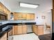 A kitchen featuring light wood cabinetry, black countertop, and stainless steel appliances at 2609 Waterford Way # B, Palmetto, FL 34221