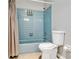 Cozy bathroom featuring blue tile, shower and tub combination, and neutral tan flooring at 2705 20Th Avenue W Dr, Bradenton, FL 34205