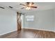 Spacious bedroom with wood-look floors, a ceiling fan, a window, and a sliding barn door to the ensuite bathroom at 2705 20Th Avenue W Dr, Bradenton, FL 34205